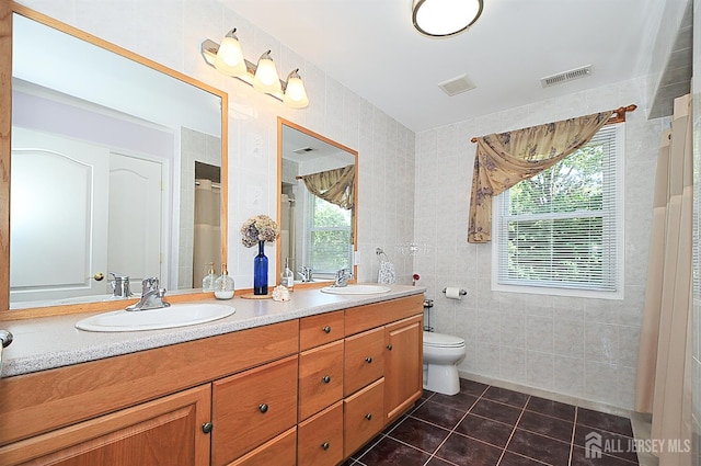 1329 Crown Ln, South Plainfield, NJ 07080 - full bath featuring tile walls, tile patterned flooring, double vanity, plenty of natural light, and a shower with door