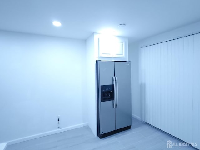 kitchen with stainless steel fridge and white cabinets