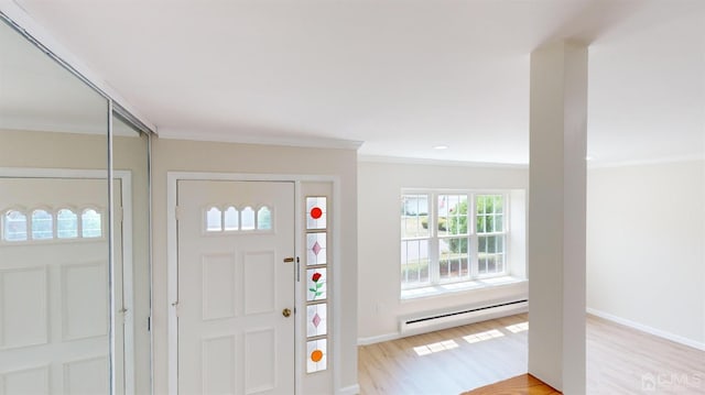 entrance foyer with baseboard heating, crown molding, and light hardwood / wood-style flooring