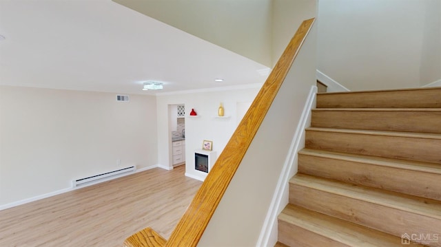 stairway featuring hardwood / wood-style flooring and baseboard heating