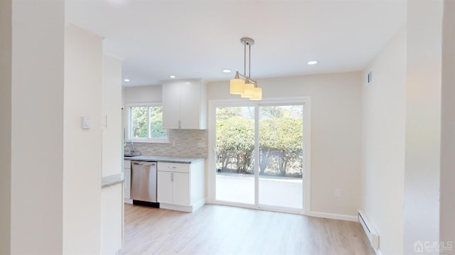 kitchen featuring backsplash, stainless steel dishwasher, white cabinets, pendant lighting, and a baseboard heating unit