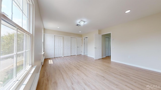 unfurnished bedroom featuring light hardwood / wood-style floors and multiple windows