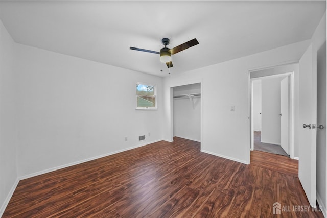 unfurnished bedroom featuring dark wood-type flooring, ceiling fan, and a closet