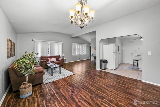 living room with vaulted ceiling, light hardwood / wood-style floors, and a notable chandelier