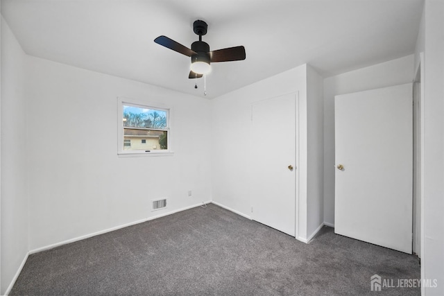 carpeted spare room with ceiling fan