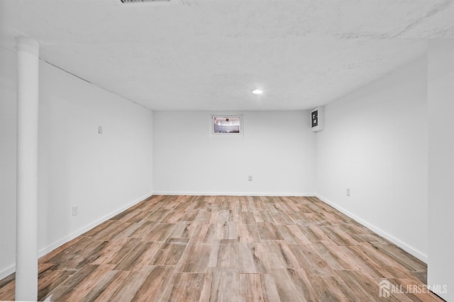 basement with light hardwood / wood-style flooring