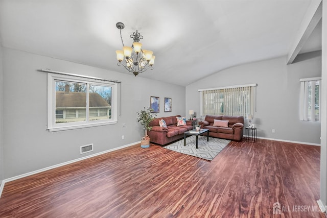 living room with an inviting chandelier, lofted ceiling, and hardwood / wood-style floors