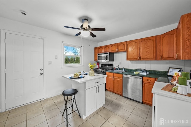 kitchen with tasteful backsplash, sink, a kitchen breakfast bar, a center island, and stainless steel appliances