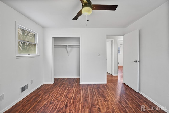 unfurnished bedroom featuring dark wood-type flooring, a closet, and ceiling fan