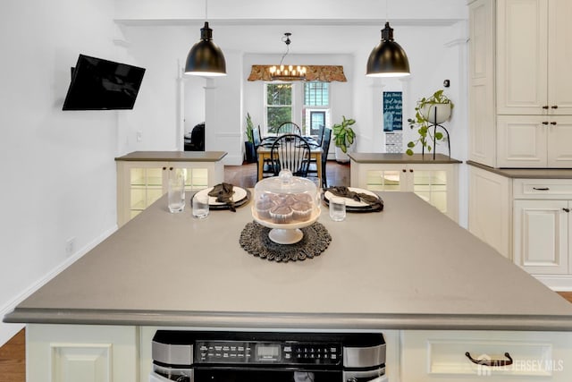 369 N Main St, Milltown, NJ 08850 - kitchen featuring a kitchen island, a chandelier, pendant lighting, white cabinetry, and dark countertops