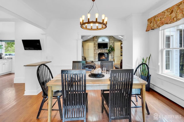 369 N Main St, Milltown, NJ 08850 - dining area featuring a baseboard radiator, hardwood / wood-style flooring, a stone fireplace, a chandelier, and ornamental molding