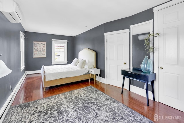 369 N Main St, Milltown, NJ 08850 - bedroom with a wall mounted air conditioner, wood finished floors, and a baseboard radiator