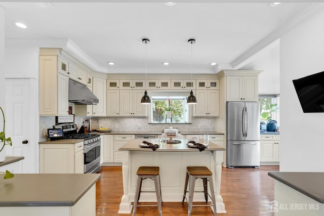 369 N Main St, Milltown, NJ 08850 - kitchen with appliances with stainless steel finishes, a center island, under cabinet range hood, ornamental molding, and plenty of natural light