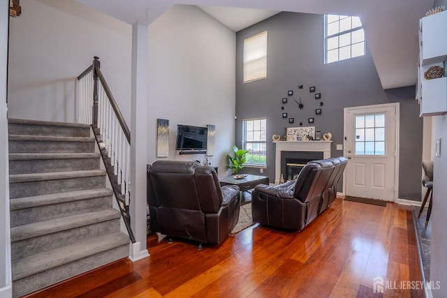 108 Jared Dr, North Brunswick, NJ 08902 - living room featuring a high ceiling, healthy amount of natural light, wood finished floors, stairway, and a glass covered fireplace