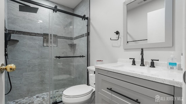 full bathroom featuring toilet, a stall shower, and vanity