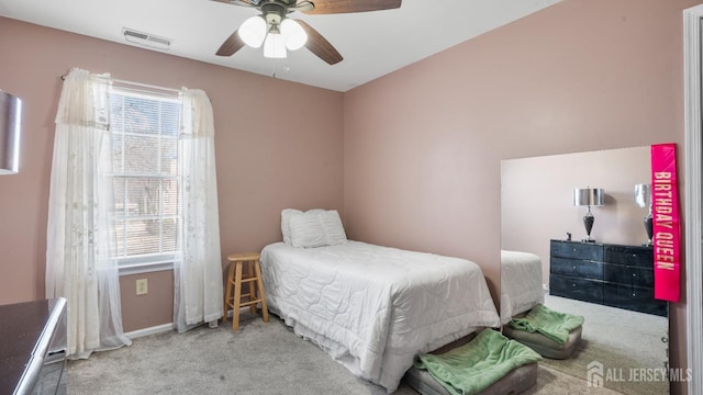 carpeted bedroom featuring baseboards, visible vents, and a ceiling fan