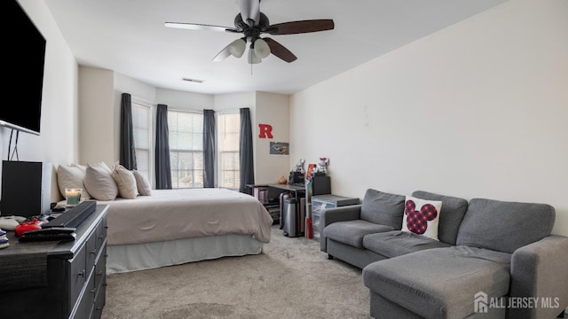 bedroom featuring a ceiling fan, light colored carpet, and visible vents