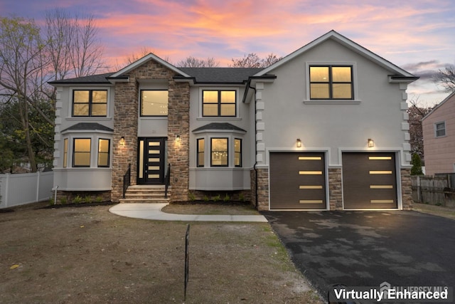 view of front facade with stucco siding, stone siding, aphalt driveway, and fence