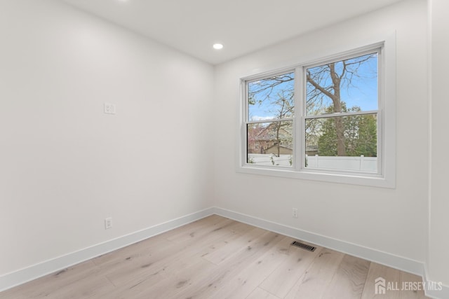 empty room with light wood finished floors, baseboards, visible vents, and recessed lighting