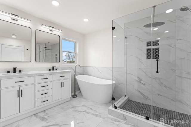 full bathroom with double vanity, marble finish floor, a marble finish shower, and a sink
