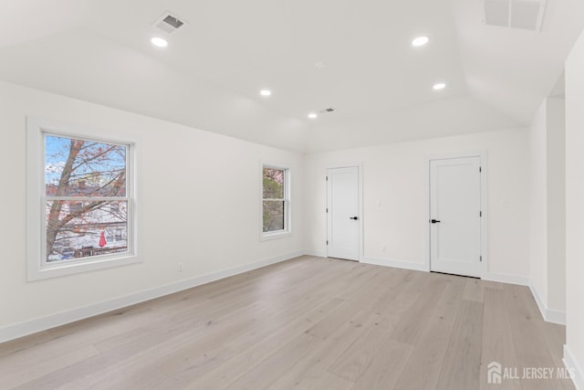 spare room with a wealth of natural light, light wood finished floors, and visible vents
