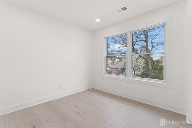 unfurnished room featuring baseboards, a healthy amount of sunlight, and visible vents