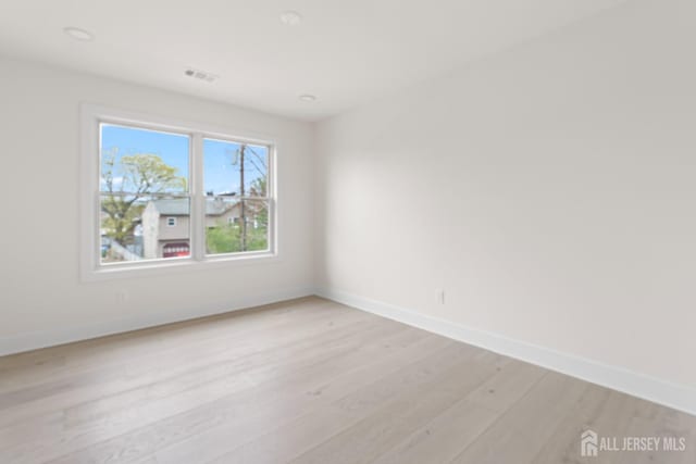 empty room featuring baseboards and light wood-style floors