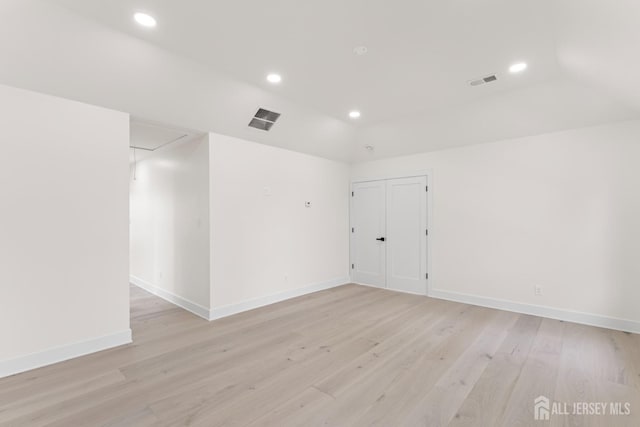 unfurnished room featuring attic access, light wood-type flooring, visible vents, and recessed lighting