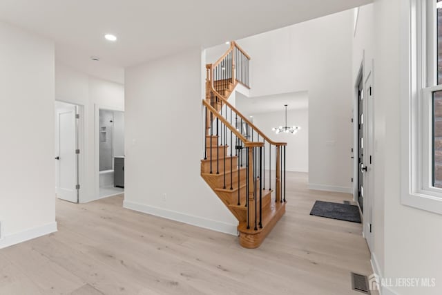 stairway with baseboards, wood finished floors, visible vents, and recessed lighting