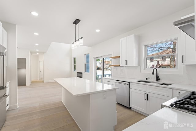 kitchen featuring dishwasher, plenty of natural light, a sink, and a kitchen island
