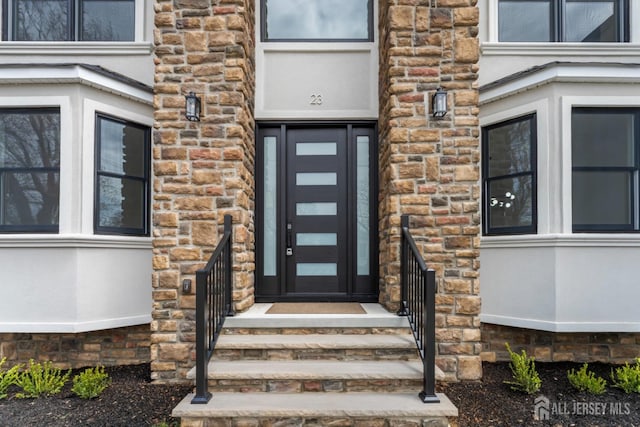 property entrance featuring stone siding