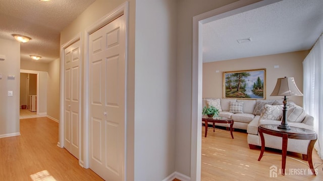 741-B Nautilus Ct Unit B, Monroe, NJ 08831 - hallway featuring a textured ceiling, light wood-type flooring, and baseboards