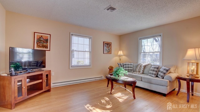 741-B Nautilus Ct Unit B, Monroe, NJ 08831 - living area featuring baseboard heating, a textured ceiling, and light wood finished floors