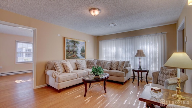 741-B Nautilus Ct Unit B, Monroe, NJ 08831 - living room featuring a baseboard heating unit, light wood-style flooring, and a textured ceiling