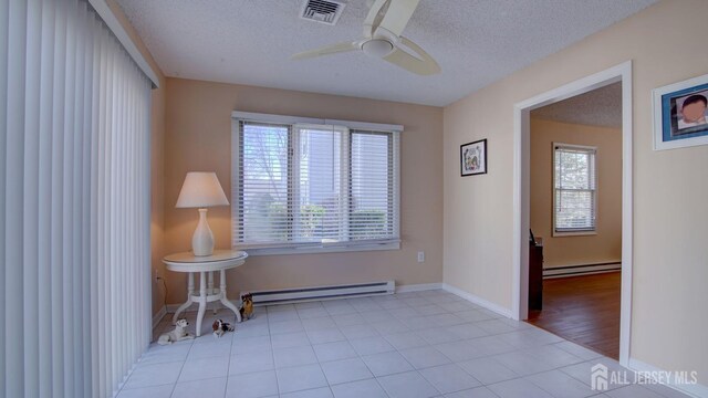 741-B Nautilus Ct Unit B, Monroe, NJ 08831 - tiled spare room featuring a baseboard radiator, plenty of natural light, a ceiling fan, and a textured ceiling