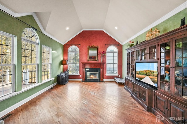 interior space featuring lofted ceiling, hardwood / wood-style flooring, and crown molding