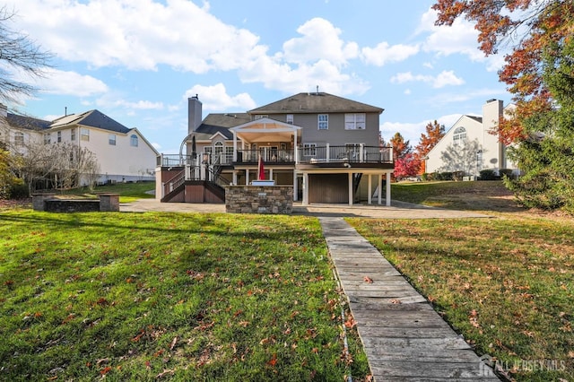 back of house with a wooden deck, a yard, and a patio