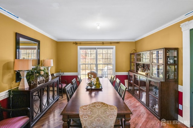 dining space featuring hardwood / wood-style floors and ornamental molding