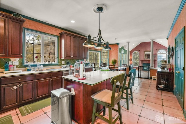 kitchen featuring lofted ceiling, sink, a center island, hanging light fixtures, and plenty of natural light