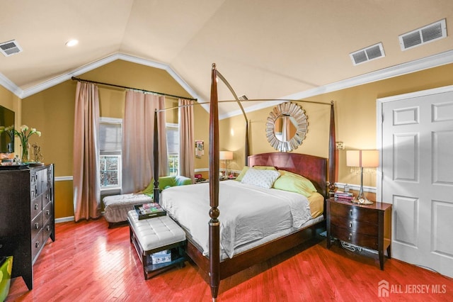 bedroom with lofted ceiling, hardwood / wood-style floors, and crown molding