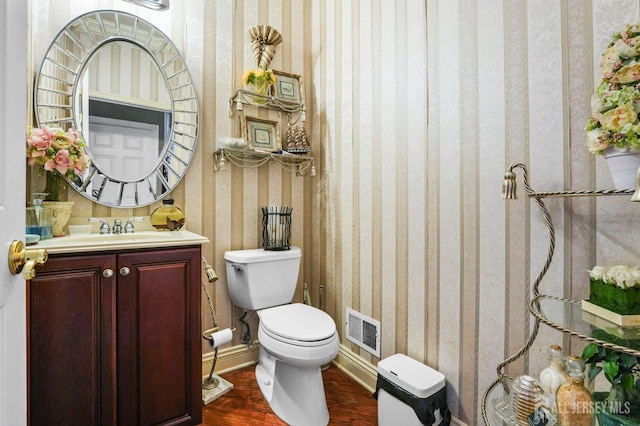 bathroom featuring vanity, wood-type flooring, and toilet