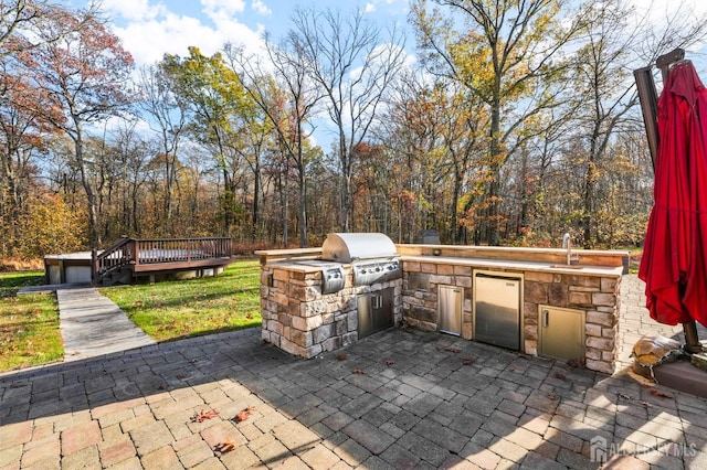 view of patio / terrace featuring exterior kitchen, sink, a deck, and grilling area