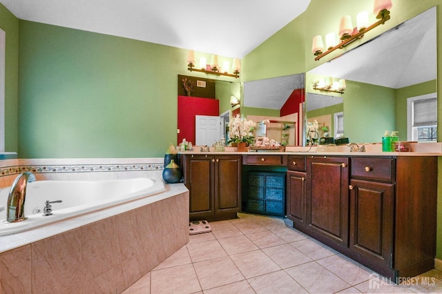 bathroom featuring vanity, lofted ceiling, a relaxing tiled tub, and tile patterned floors