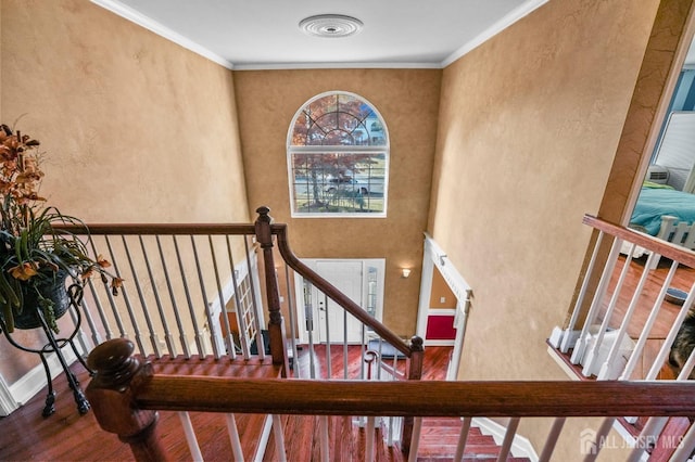 staircase with hardwood / wood-style flooring and ornamental molding