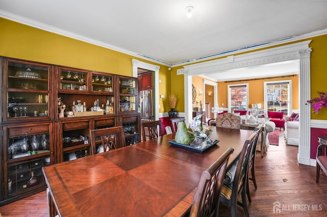 dining space with hardwood / wood-style flooring and ornamental molding