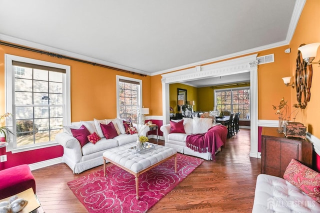 living room featuring dark hardwood / wood-style flooring, crown molding, and a wealth of natural light