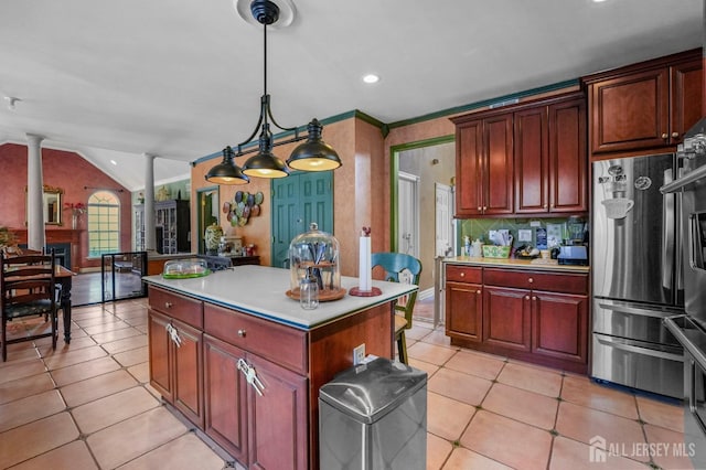 kitchen with lofted ceiling, stainless steel fridge, a kitchen island, pendant lighting, and decorative columns