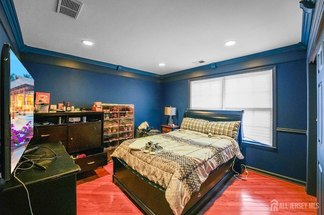 bedroom with wood-type flooring and ornamental molding