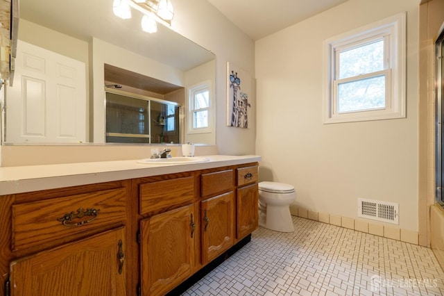 bathroom featuring toilet, baseboards, visible vents, and a wealth of natural light