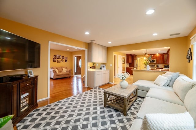 living area featuring baseboards, wood finished floors, and recessed lighting